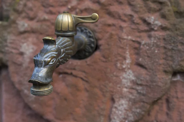 Alter Wasserhahn auf einer Sandsteinmauer montiert — Stockfoto