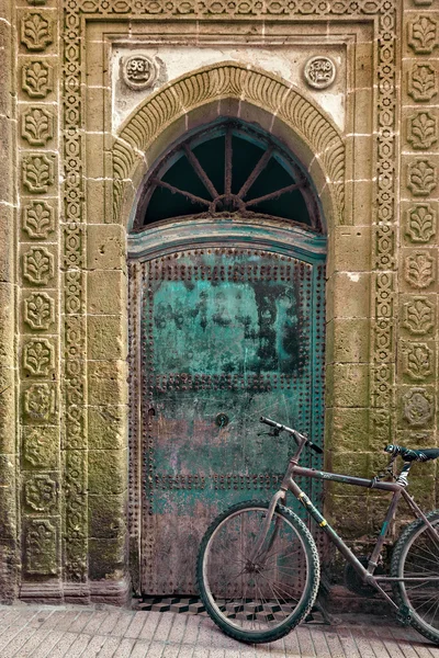 Staré kolo před zvětralých dveře, Maroko — Stock fotografie