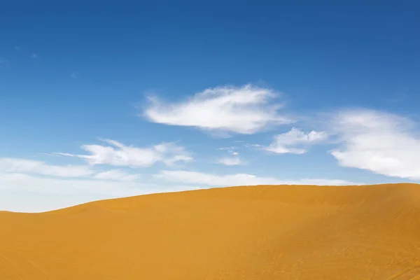 Woestijn achtergrond met blauwe hemel — Stockfoto