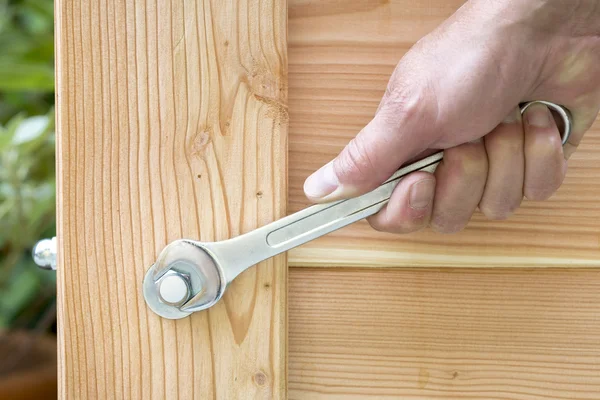 Hand tightening a domed cap with a wrench — Stock Photo, Image