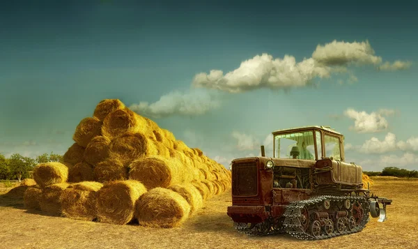 Haystacks a pályán. régi traktor és széna verem — Stock Fotó