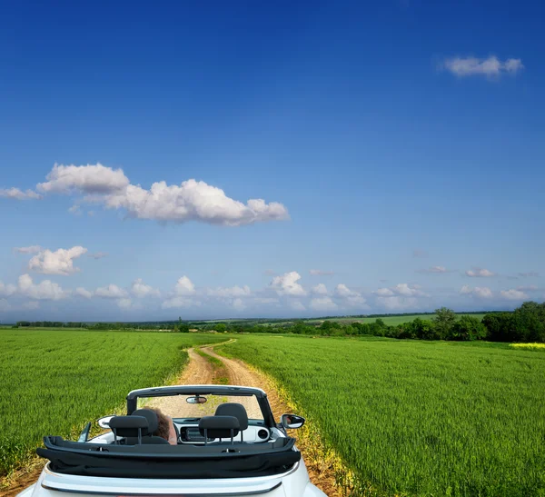 White convertible on a country road through fields — Stock Photo, Image