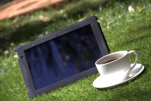 Tablet pc preto e uma xícara de café — Fotografia de Stock