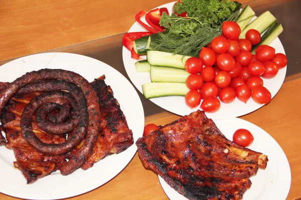 Grilled ribs and sausages with vegetables — Stock Photo, Image