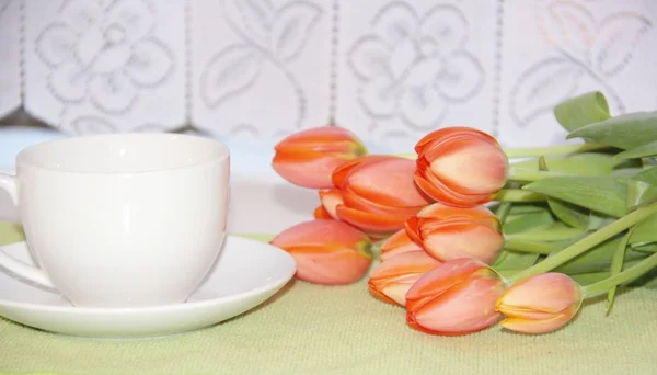 Flores de tulipán y una taza de té — Foto de Stock