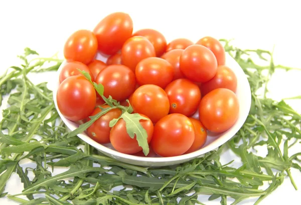 Свежие помидоры черри в тарелке и ракете — стоковое фото