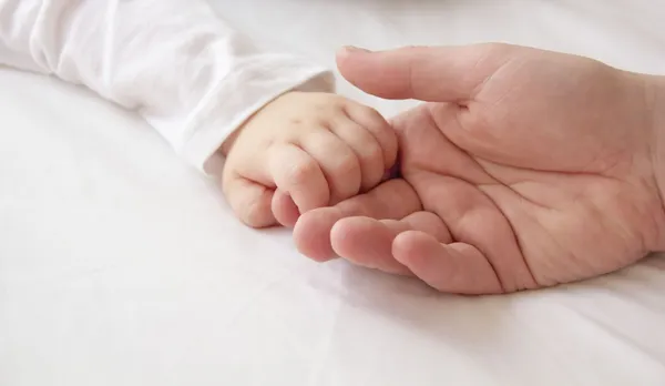 Tiny hand van zoon en grote hand van Papa Stockfoto