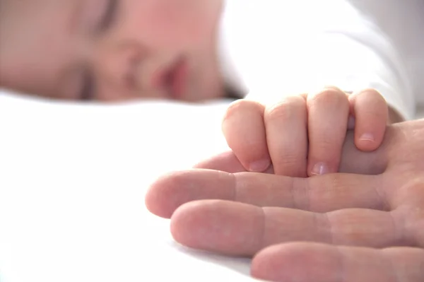 Napping jongetje houdt zijn papa hand Rechtenvrije Stockafbeeldingen