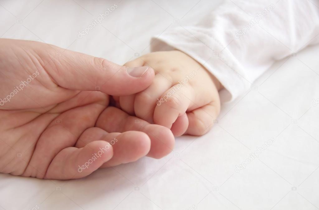 Hands of father and little child together