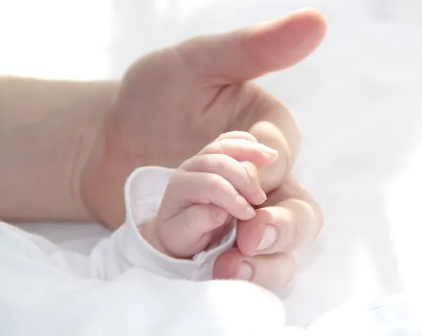 Stor hand av far och liten hand av baby — Stockfoto