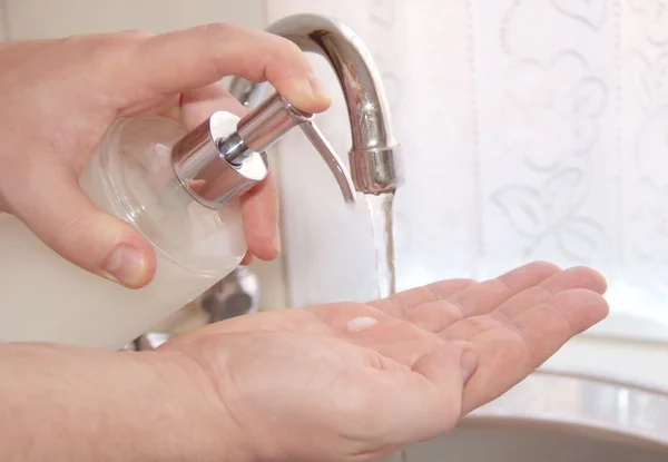 Чоловік миє руки рідким миттям рук — стокове фото