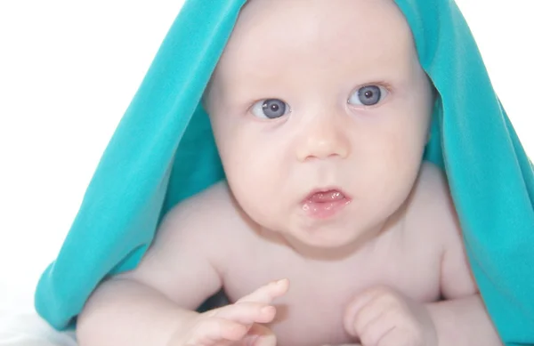 Lindo bebé niño bajo cubierta azul brillante — Foto de Stock