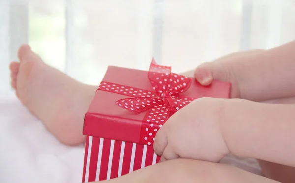 Niño pequeño con un regalo rojo — Foto de Stock