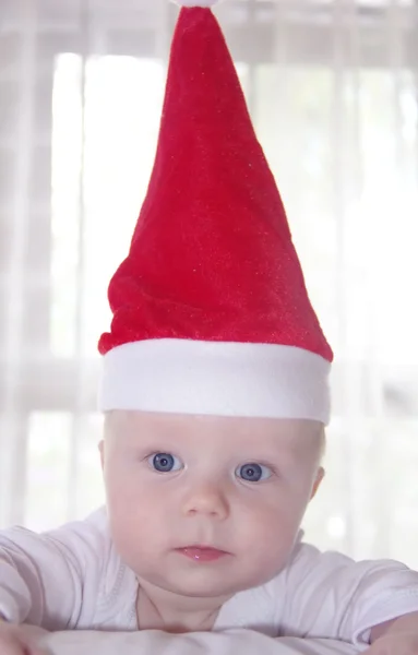 Baby in een rode Nieuwjaar hoed Stockfoto