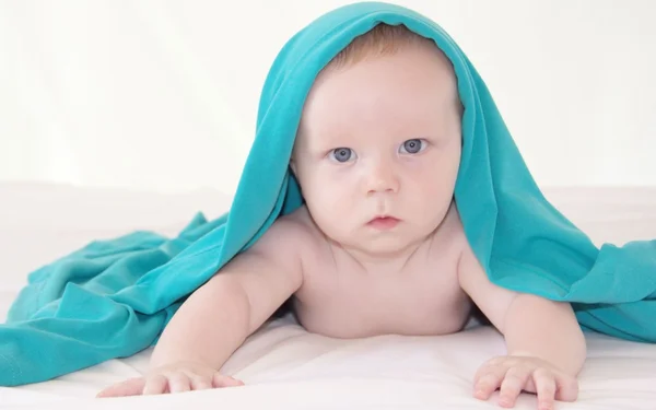 Baby boy under bright blue cover — Stock Photo, Image