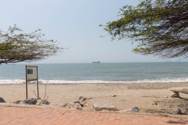  Karayipler 'de büyük bir gemisi olan iki ağacın ortasında havalimanı plajı bilgilendirme tabelası.