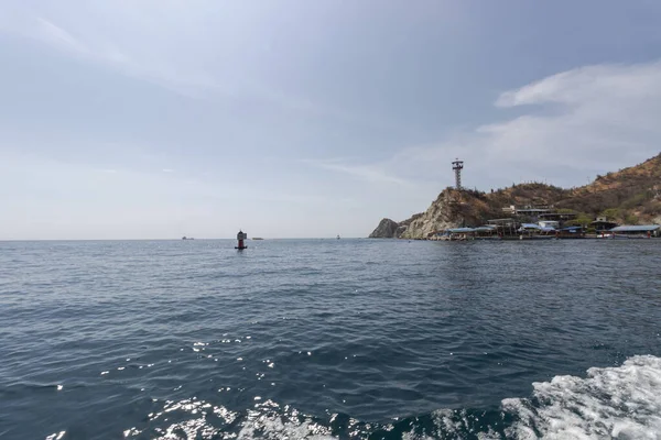 Beyaz Sahil Santa Marta Kolombiya tepesi, tepe örtüsü kulesi ve kırmızı şamandırası var.