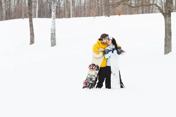 Jovem e mulher com pranchas de neve treir — Fotografia de Stock