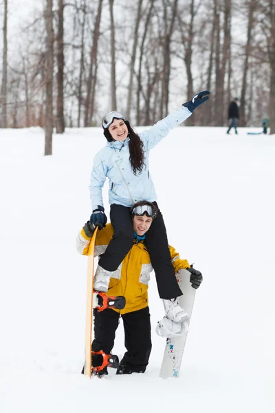 Jovem e mulher com pranchas de neve treir — Fotografia de Stock