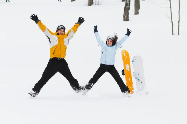 Jovem e mulher com pranchas de neve treir — Fotografia de Stock