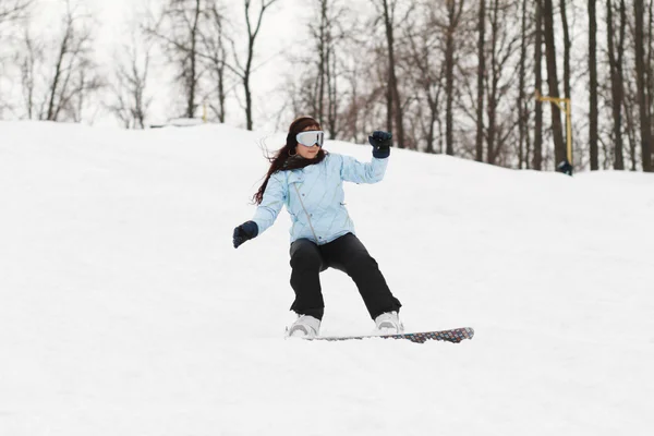 Jovem mulher no snowboard — Fotografia de Stock