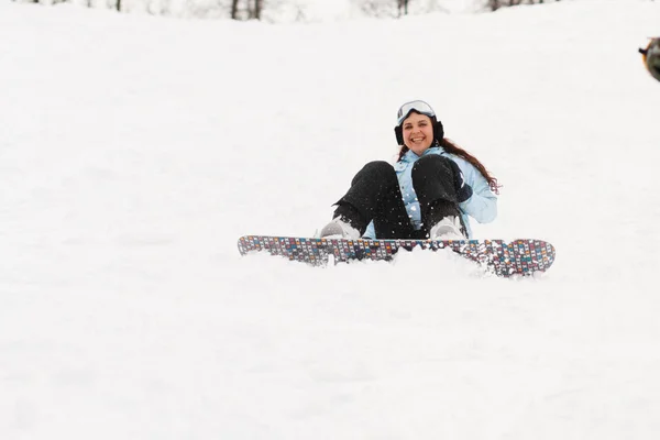 Mladá žena na snowboardu — Stock fotografie