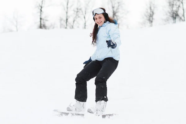 Mladá žena na snowboardu — Stock fotografie