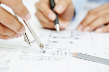 Macro of hands on blueprint