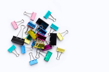 Beyaz arkaplanda renkli ofis kağıdı ataçları.