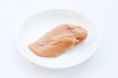 Pişmemiş çiğ tavuk göğsü fileto beyaz tabakta beyaz arka planda.