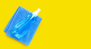 Mavi havluyla plastik şişedeki pencere temizleyicisi.