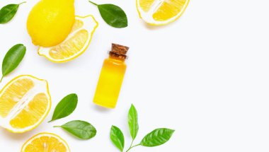 Beyaz arka planda gerekli yağ şişesiyle taze limon..