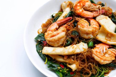 Kutsal fesleğen yaprakları ve deniz ürünleriyle kızartılmış baharatlı vermicelli.