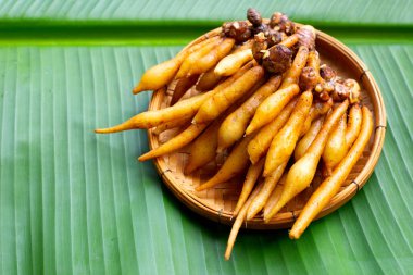 Muz yaprağında parmak kökü olan bambu sepeti.