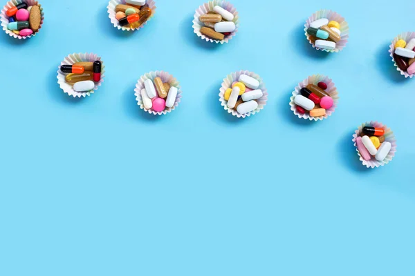 Színes Tabletták Kapszulákkal Tablettákkal Kék Hátterű Muffin Csomagolásban — Stock Fotó