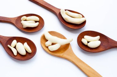 Beyaz arka planda ahşap kaşıklarla soyulmuş genç kızıl..