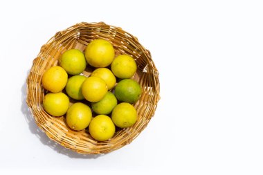 Beyaz arka planda bambu sepetinde limonlar.