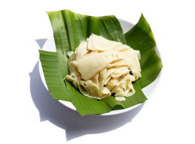 Bannana yaprağında beyaz tabakta korunmuş bambu filizi.