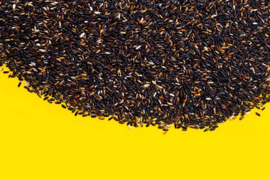 Sarı arka planda çiğ siyah pirinç..