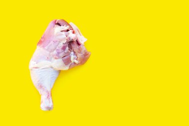 Sarı arka planda çiğ tavuk budu..