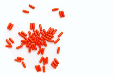 Beyaz arka planda turuncu kapsül hapları.