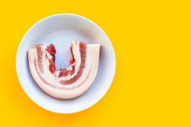 Sarı arka planda beyaz kasede domuz eti..