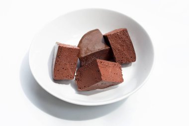 Beyaz arka planda beyaz tabakta tavuk kanı tofusu.