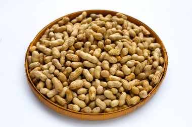 Beyaz arka planda bambu sepetinde çiğ fıstık..