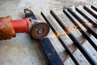 Yaklaş, üçkağıtçıyla çalışan bir adam. Demir kapı onarımı