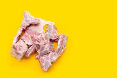 Sarı arka planda çiğ domuz kemiği.