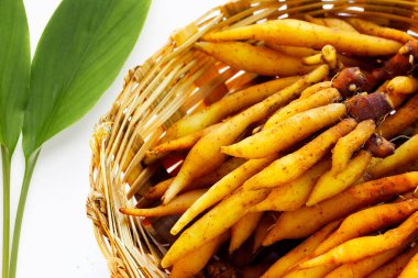 Parmak kökü beyaz arkaplanda bambu sepetinde.