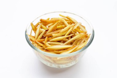 Beyaz arka planda cam kasede dilimlenmiş parmak kökü..