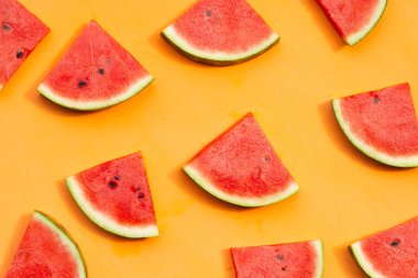 Turuncu arka planda karpuz dilimleri.