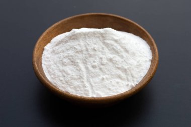 Koyu arkaplanda ahşap kasede kabartma tozu..